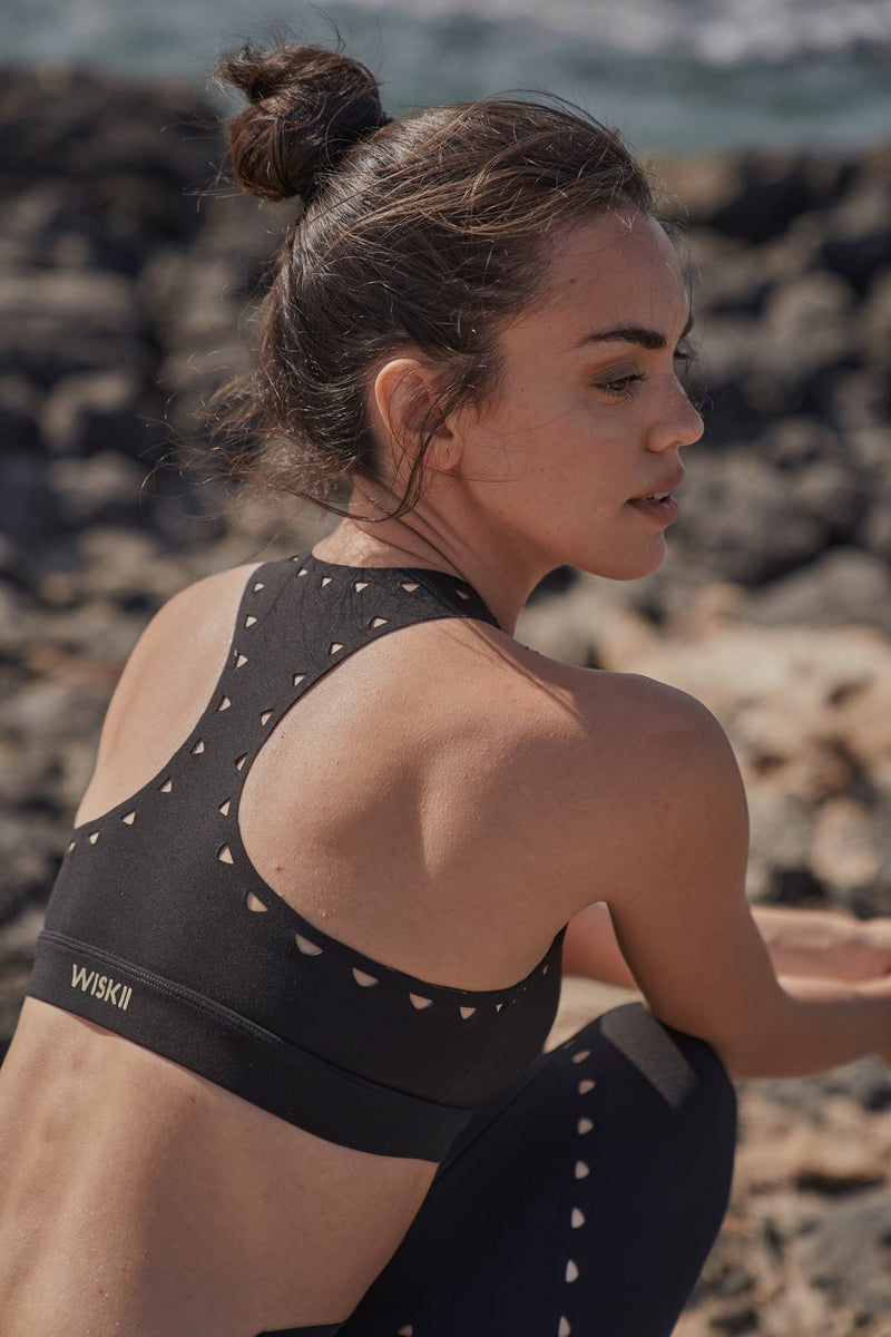 Model wears Racerback Laser Cut Sports Bra + V-waist Laser Cut Sports Legging | WISKII 